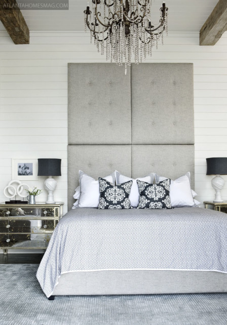 To balance out the hard lines of the planked walls in the master bedroom, the designers added softer, feminine touches: An upholstered headboard, mirrored side table and crystal chandelier give the room an air of laid-back luxury.