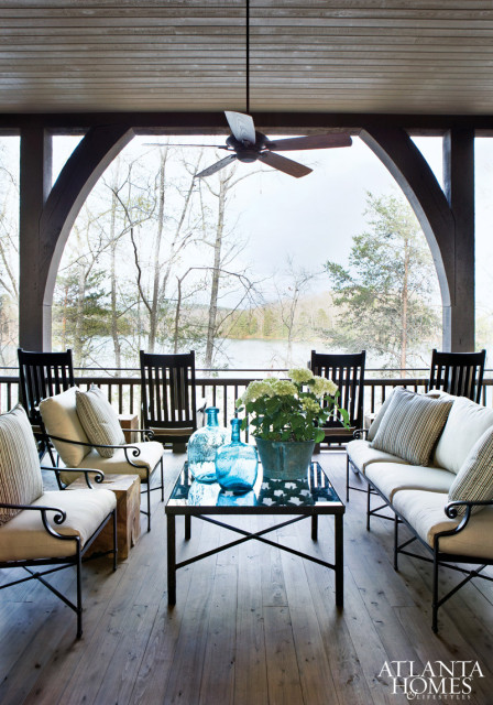 Vintage finds like an antique iron gate-turned-coffee table, as well as the requisite lake house rocking chairs, bring character to the exterior porch, maximizing the family’s living space.