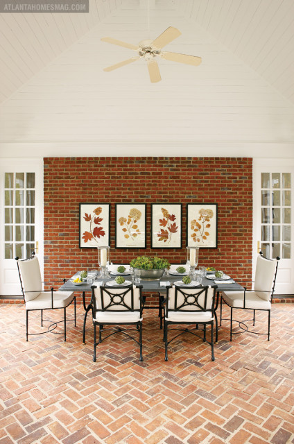 Near a Belgian limestone table, a quartet of framed oakleaf and mophead hydrangea prints lend outdoorsy ambience to the screened-in porch.