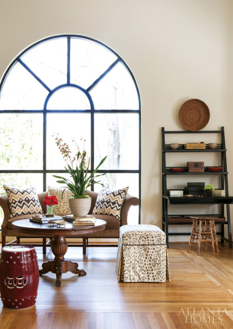 “Arches are one of my favorite architectural elements,” explains Bentley. Black lacquer Asian-inspired bookcases flank the window and sitting area.