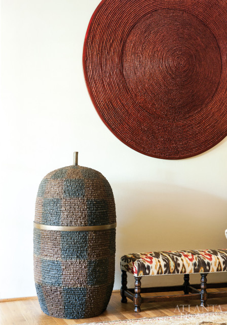 The reception area boasts bronze sculptures and an antique bench upholstered in an ikat design.