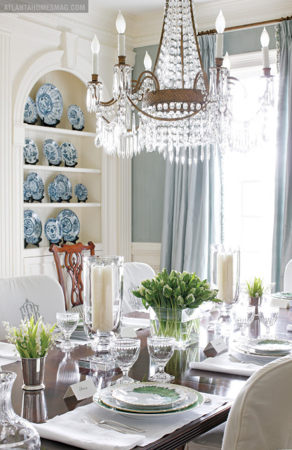 The stylish table setting in the dining room features glass hurricanes and crystal stemware by William Yeoward. Greenleaf china by Anna Weatherly, one of the many patterns Elsey has collected over the years, is set upon custom linens, their monograms matching those of each slipcover. A display niche featuring Chinese porcelain plates from Jane Marsden Antiques is further evidence of Elsey’s passion for delicate tableware.