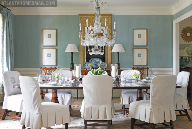 The dining room sparkles in its well-edited details, with pleated slipcovers adding a charming touch around the traditional mahogany table. Meanwhile, a Trumeau mirror brilliantly shines in the light of the crystal Niermann Weeks chandelier. Framed intaglios and silk draperies further enhance the elegant look.