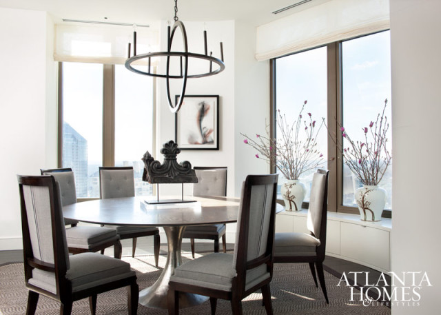 A round Julian Chichester dining table, available at Holland & Company, and Noir’s Montel metal chandelier echo the curved walls of the residence’s dining area. The 1940s-era French Modern chairs are upholstered in a Holland & Sherry grey wool.