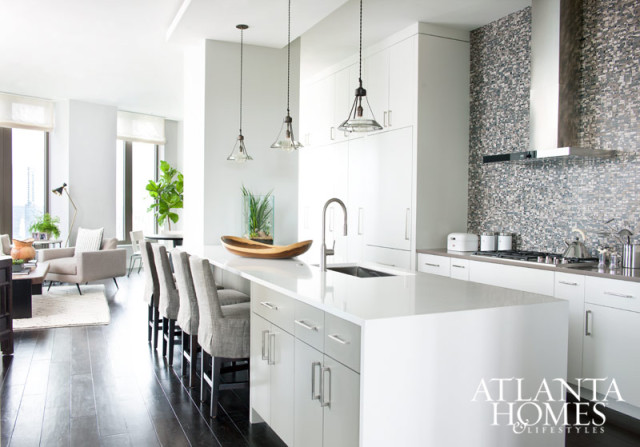 Harrison Design’s Robert Tretsch and Karen Ferguson selected the kitchen cabinetry and finishes for this unit, including the Lines Safari Brown tile backsplash from Porcelanosa, Wolf appliances, an integrated Subzero refrigerator/freezer panel and stainless-steel faucets and sinks from KWC. The set of 1930s-era pendant lights, selected by Westbrook, are from Radio Guy. Barstools, Bungalow Classic. Island counter, Caesarstone. Perimeter counter, Silestone.
