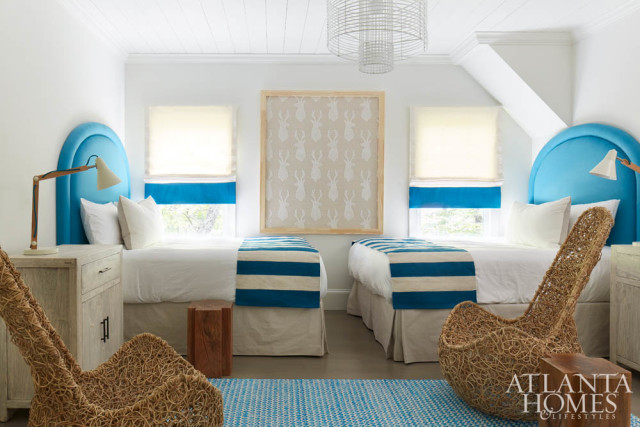 In Blakely’s bedroom, whimsical twig chairs and blue accents impart an “Alice in Wonderland vibe,” says Douglass. The beds are draped with runners from Crate & Barrel. The framed fabric is Kay Douglass Interiors.