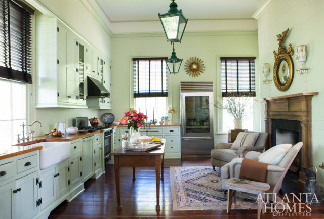 The new kitchen features heart pine countertops made from the original 19th-century floorboards from the Jenkins family barn. A pair of club chairs with pillows from Dixon Rye and a Regency girandole mirror frame the period mantel from Madison, Georgia. Throw, Gramercy. Cutting board, Foxglove Antiques. Candelabra, Formations through Jerry Pair.