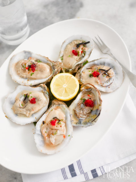 Oysters on the half shell, with yuzu, pickled ginger juice, red tobiko, sweet chili vinaigrette and shiso micro greens.