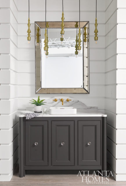 A wall-mounted faucet and vessel sink from Kohler are striking atop custom cabinetry painted Sherwin-Williams Urbane Bronze.