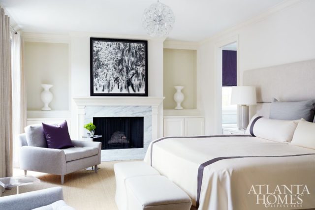 Beams of sunlight flood into the master bedroom from the adjoining courtyard; the serene space elegantly pairs textured neutrals with edited bursts of color, including violet accents on the custom silk bedding from Kay Douglass Interiors.