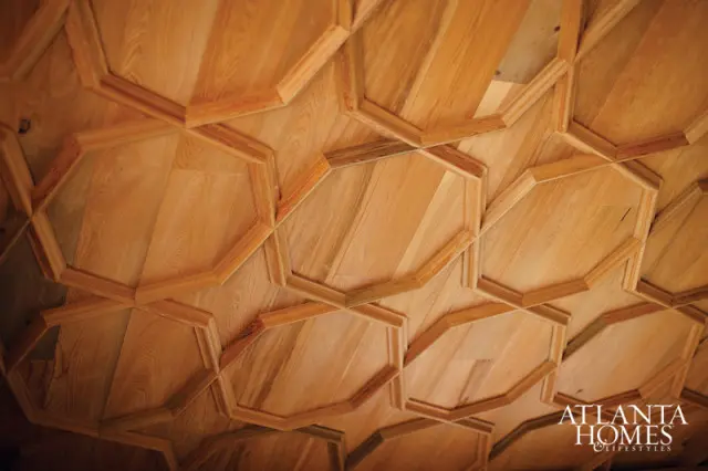 Close-up of a wooden ceiling with a geometric pattern of octagons and inlaid wood panels.
