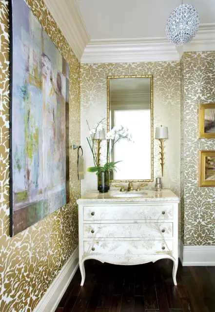 Powder room with gold damask wallpaper, a white vanity with floral carvings, granite countertop, and a large abstract painting.
