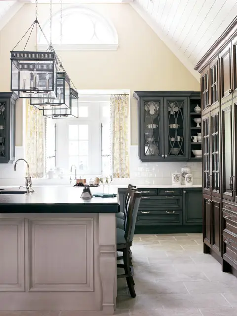 Kitchen with dark gray cabinetry, white subway tile backsplash, and a large white island with a dark countertop. Three black lantern pendant lights hang above the island.
