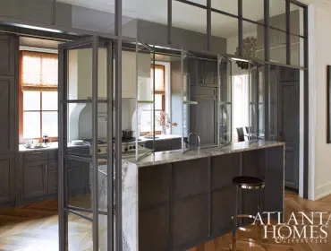 Dark wood kitchen with marble island and herringbone wood floors.