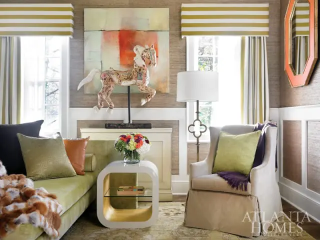 Living room with a lime green sofa, upholstered armchair, textured wallpaper, and a decorative horse sculpture on a mantelpiece.