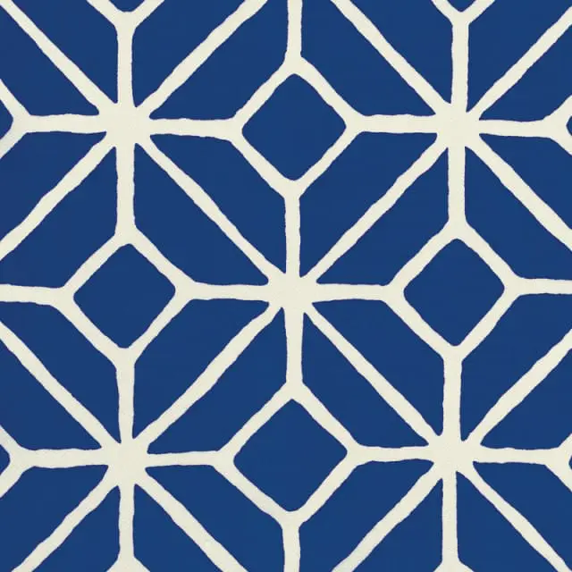 Close-up of a fabric pattern with a geometric design of interlocking white lines on a royal blue background.