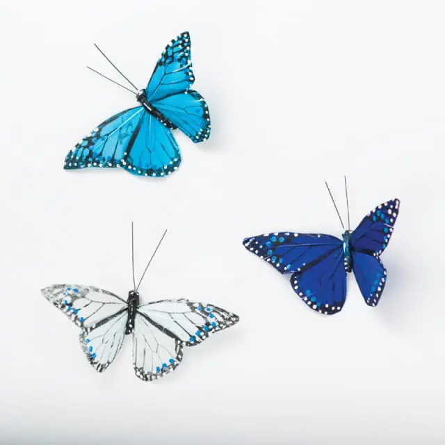 Three decorative butterflies with blue and white patterned wings against a white background.