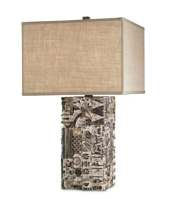 Rectangular table lamp with a textured, mosaic-like base composed of various metal and found objects, topped with a natural linen rectangular shade.