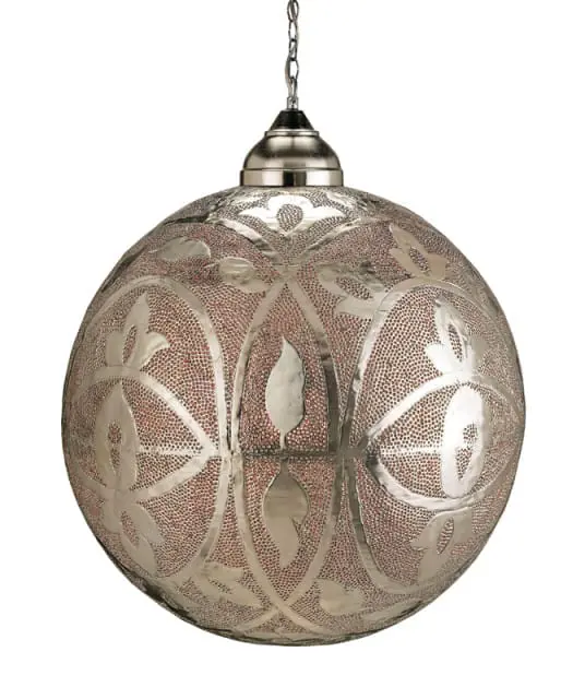 Close-up of a large, round, silver metal pendant light with intricate cut-out floral and leaf patterns over a textured, reddish-brown background.