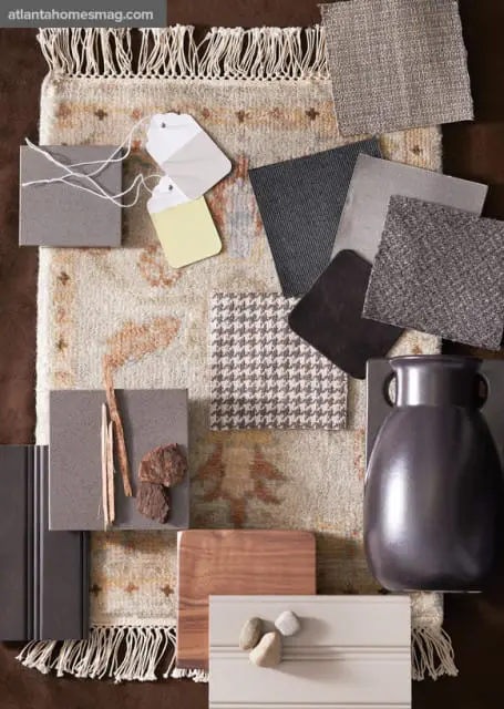 Mood board with fabric swatches, stone samples, wood, and a ceramic vase in neutral tones.
