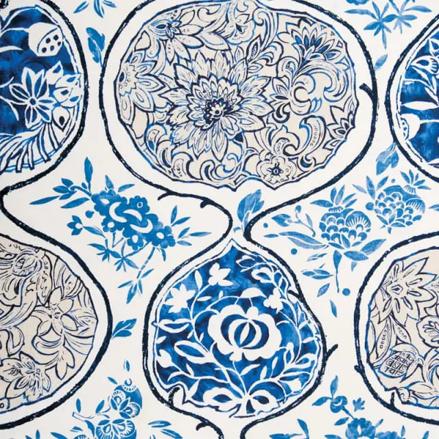 Blue and white chinoiserie pattern with floral motifs and stylized fruit within quatrefoil shapes.