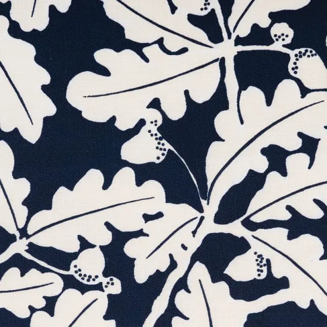Close-up of a navy blue and white fabric pattern featuring oak leaves and acorns.