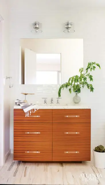 Modern bathroom with a floating wood vanity, white subway tile backsplash, speckled countertop, and a large mirror.