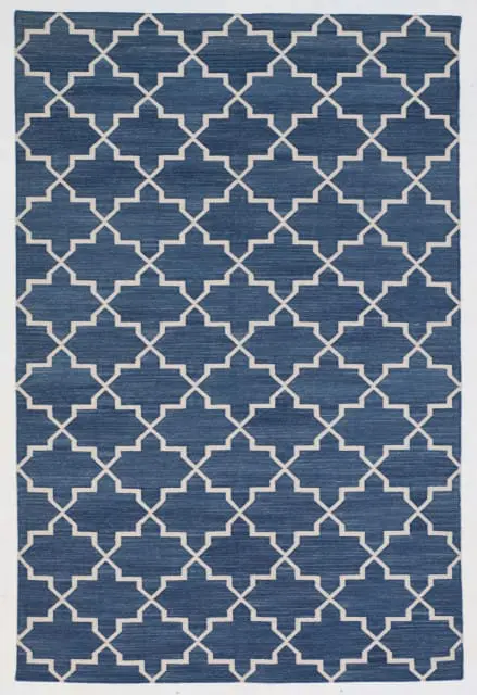 Close-up of a blue rug with a white quatrefoil pattern.