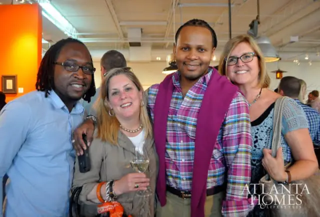 Four people posing for a photo, with a logo for Atlanta Homes & Lifestyles in the lower right