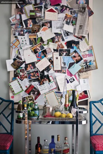 Bulletin board covered in photos, cards, and letters, with a bar cart below stocked with bottles, lemons, and ice bucket.