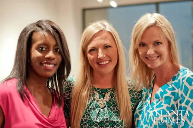 Katie Miner, Amanda Hall, and Mackenzie Johnson smile for a portrait. Miner wears a pink top, Hall a green patterned dress with a statement necklace, and Johnson a blue and white patterned top.