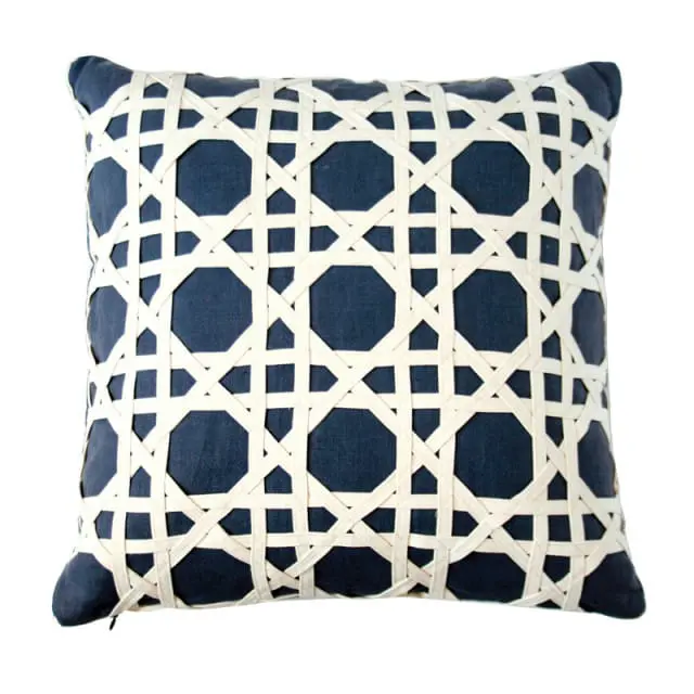 Navy blue pillow with a woven cane pattern in cream-colored straps