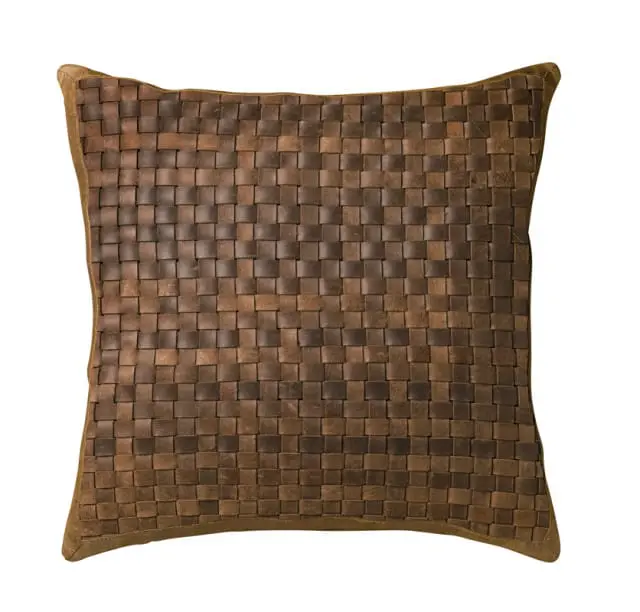 Close-up of a square pillow with a woven brown leather front and suede trim.