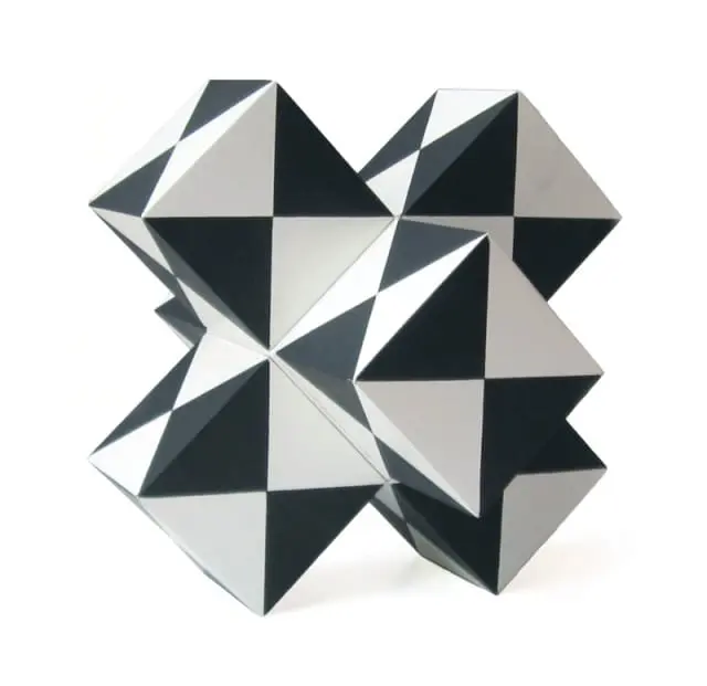 Black and white geometric sculpture with triangular facets, resembling a complex polyhedron or puzzle