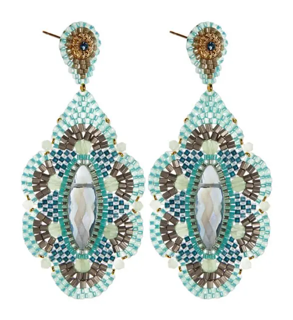 Pair of ornate beaded earrings with a central faceted clear gemstone, featuring teal, blue, gray, and pale green beads in a mosaic pattern.