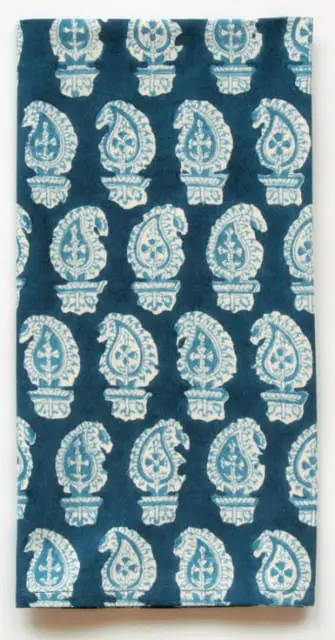 Close-up of indigo fabric with a repeating white paisley pattern.
