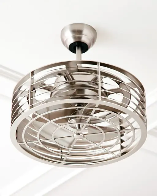 Close-up of a brushed nickel ceiling fan with a decorative metal cage and multiple blades