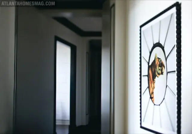Hallway with a framed tiger portrait on the wall and doorways leading to other rooms.