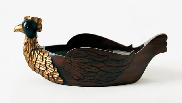 Dark wood decorative bowl carved and painted to resemble a chicken with gold leaf feathers and black accents