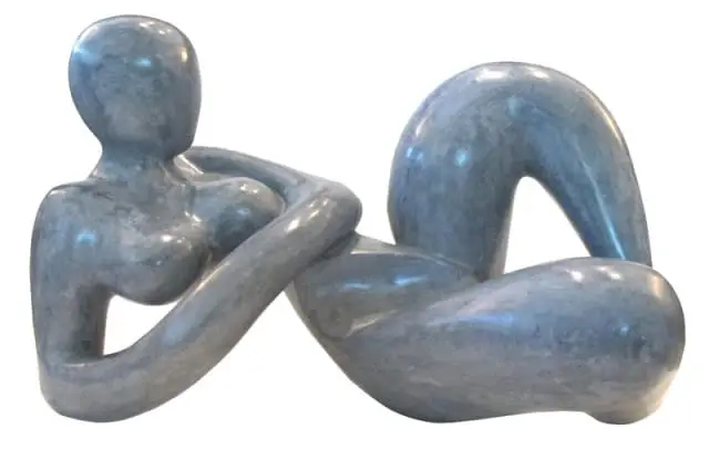 Abstract sculpture of a reclining figure carved from grey marble with visible veining.