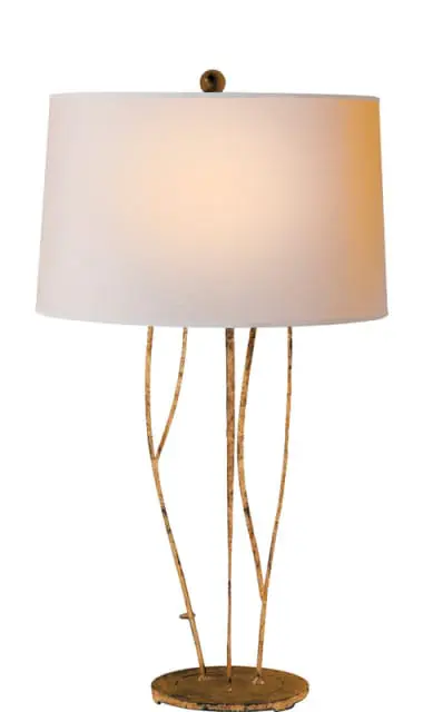 Table lamp with a white drum shade and a distressed gold metal base resembling branches.
