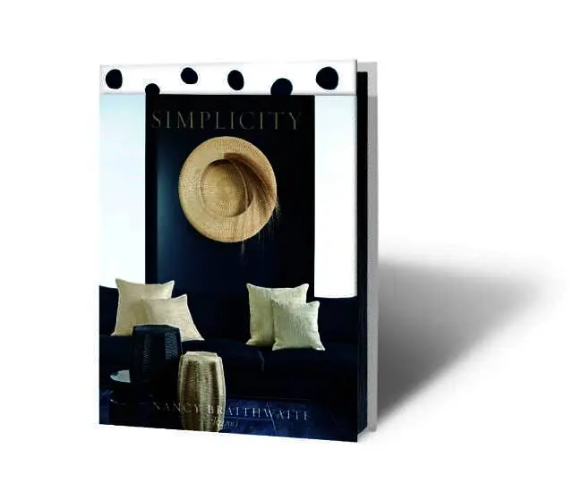 'Simplicity' book cover featuring a navy sofa with cream pillows, a woven hat on a navy wall, and the author Nancy Braithwaite.