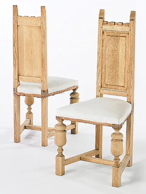 Pair of light wood dining chairs with upholstered white seats and turned legs, featuring carved details on the backrests and legs.