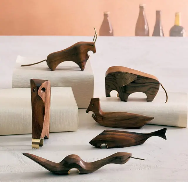 Collection of carved wooden bottle openers shaped like animals: an owl, bull, elephant, duck, fish, and snake.