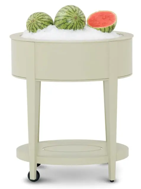 Cream-colored wooden serving cart filled with crushed ice and three whole watermelons, one cut in half.