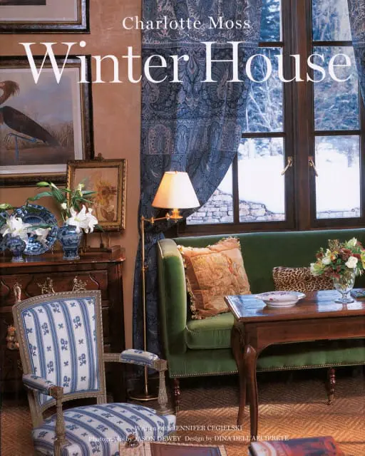 Charlotte Moss Winter House magazine cover featuring a green velvet sofa, antique armchair, and a window overlooking a snowy landscape.
