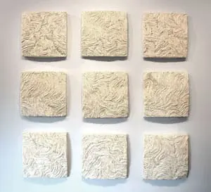 Nine square textured wall art pieces arranged in a 3x3 grid, each with a cream-colored textured surface resembling swirling patterns.