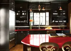 Dark wood kitchen cabinetry with glass fronts, red countertops, stainless steel appliances, and pendant lighting over a central island.