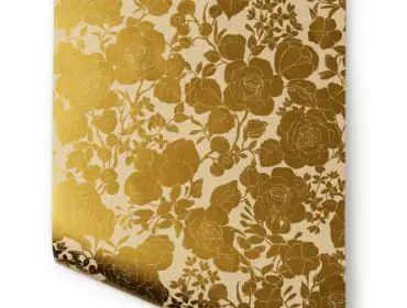 Gold floral wallpaper with a cream background, featuring a dense pattern of roses and smaller flowers.