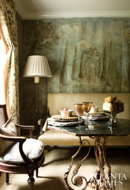 Dining room with a mural depicting a garden scene, a set table with pears, and an ornate floor lamp.
